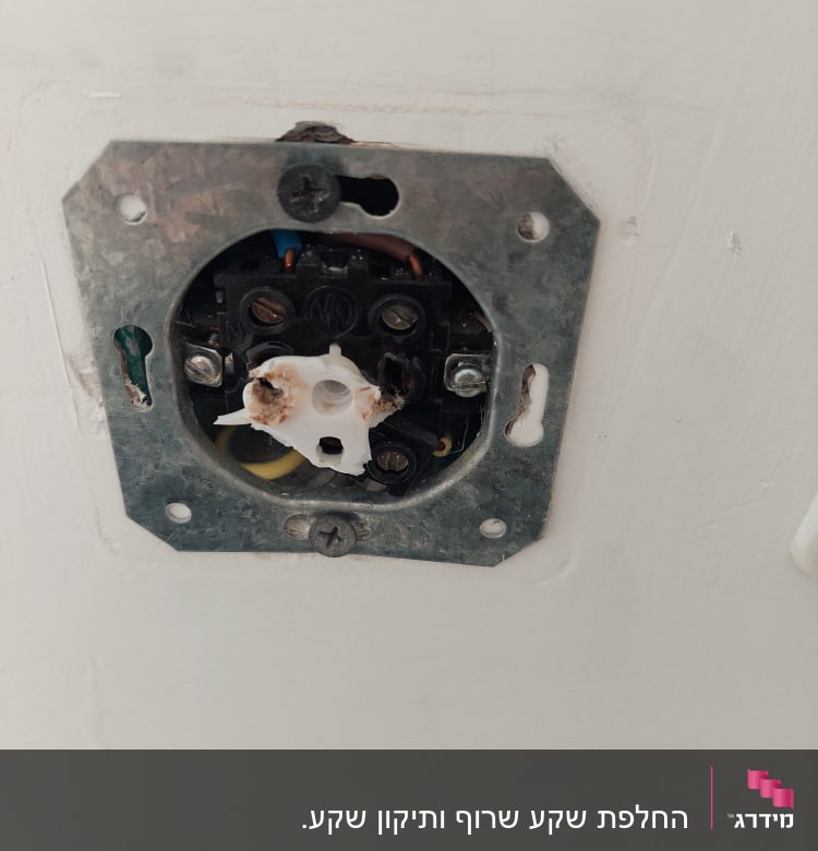 שקע חשמלי פתוח עם חוטים חשופים וקופסת מתכת